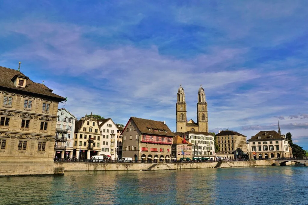 Scenic view of Lake Zurich with swans and city skyline - top things to do in Zurich